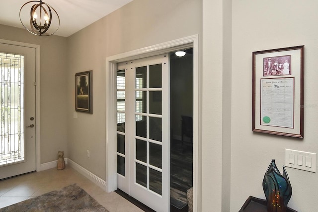 tiled foyer featuring a chandelier