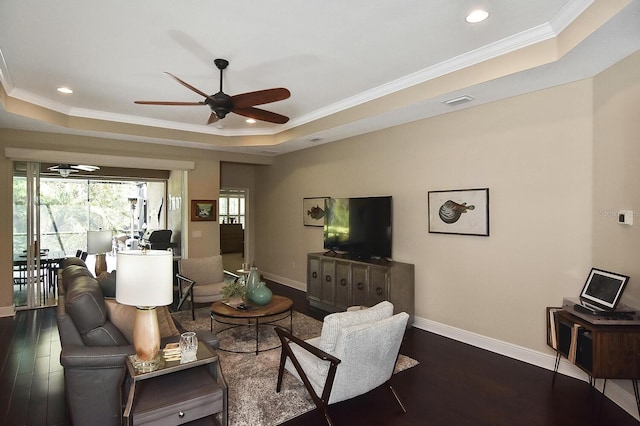 living room with ceiling fan, crown molding, dark hardwood / wood-style flooring, and a tray ceiling