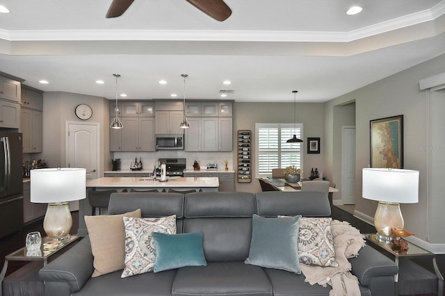 living room featuring ceiling fan and ornamental molding