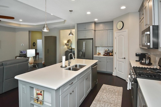 kitchen featuring gray cabinets, appliances with stainless steel finishes, sink, and an island with sink