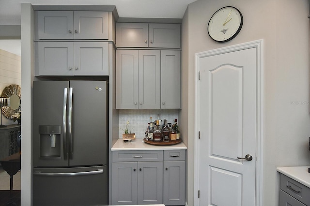 kitchen with gray cabinets, stainless steel fridge with ice dispenser, and backsplash