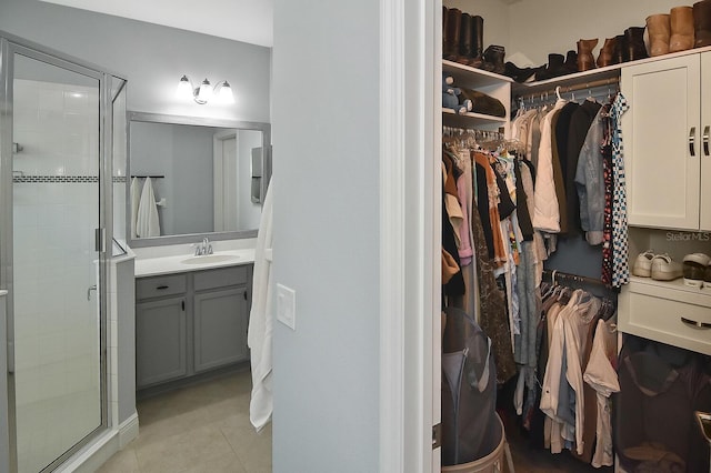 walk in closet featuring sink and light tile patterned floors