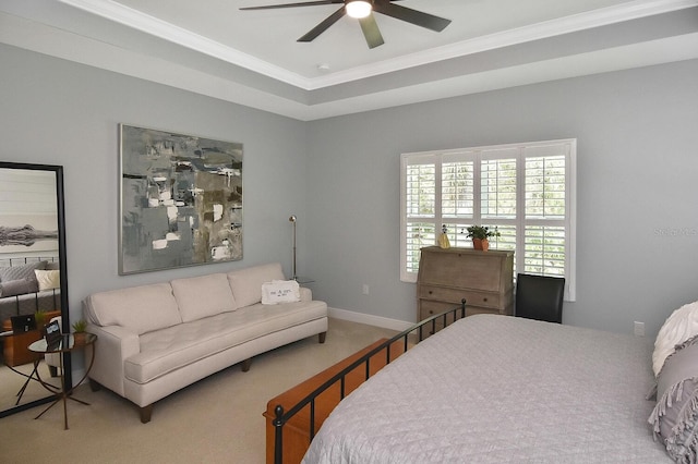 bedroom featuring ceiling fan, ornamental molding, a raised ceiling, and carpet