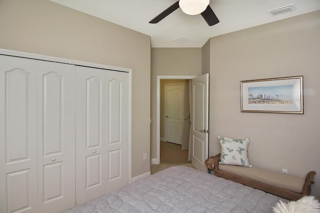 carpeted bedroom featuring ceiling fan and a closet