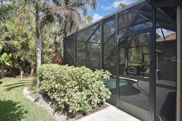 view of swimming pool with glass enclosure and a patio