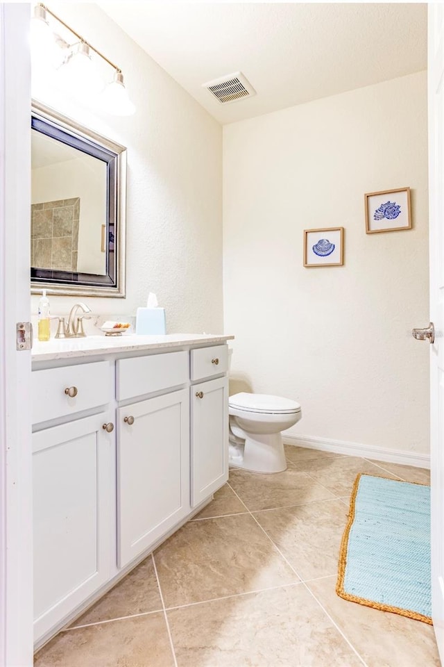 bathroom with tile patterned flooring, toilet, vanity, visible vents, and baseboards