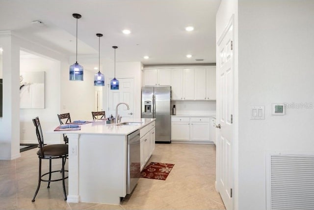 kitchen with a center island with sink, white cabinets, stainless steel appliances, light countertops, and a sink