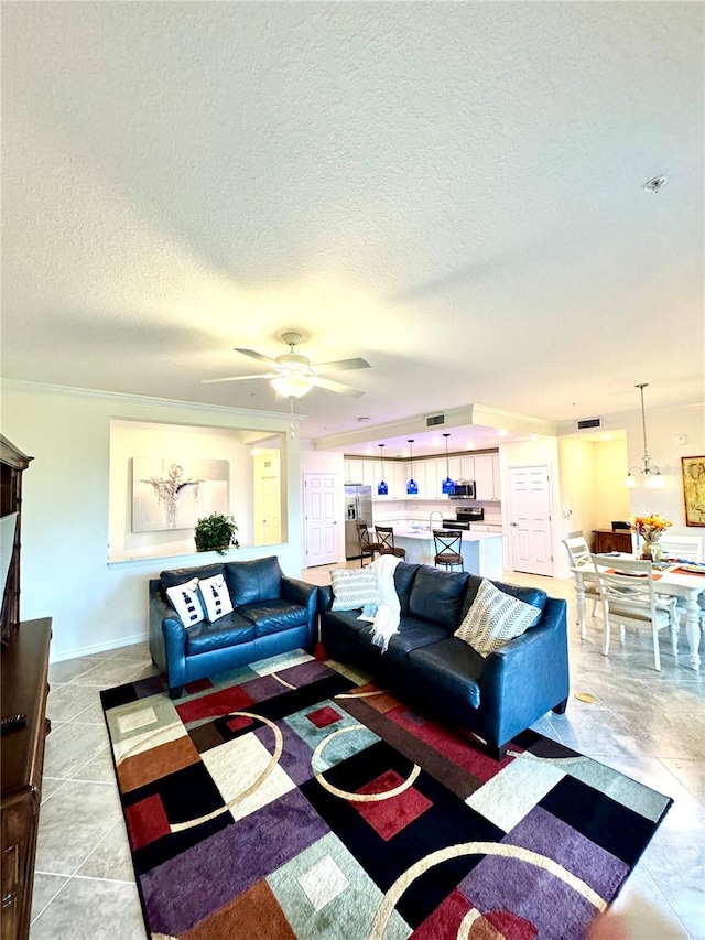 living area featuring a textured ceiling, baseboards, a ceiling fan, and crown molding