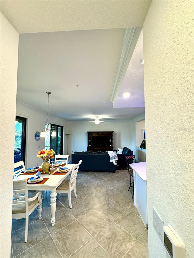 dining area with a textured wall, tile patterned flooring, a chandelier, and crown molding