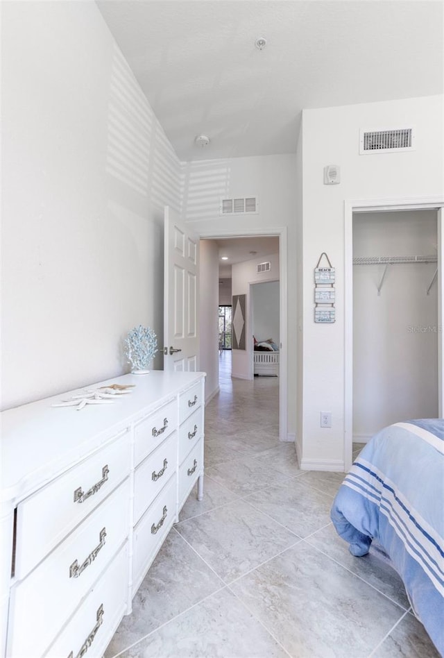 bedroom featuring baseboards, visible vents, and a closet