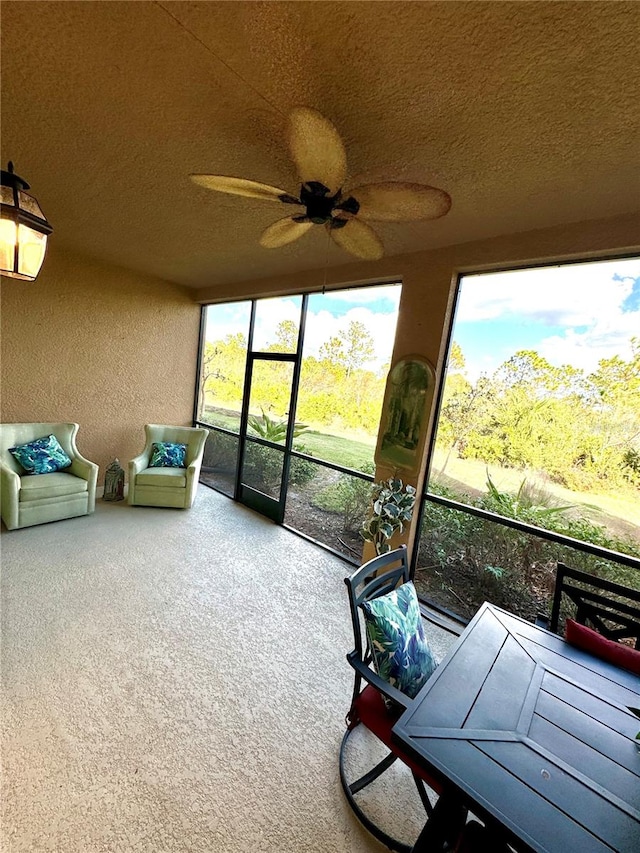 unfurnished sunroom featuring ceiling fan