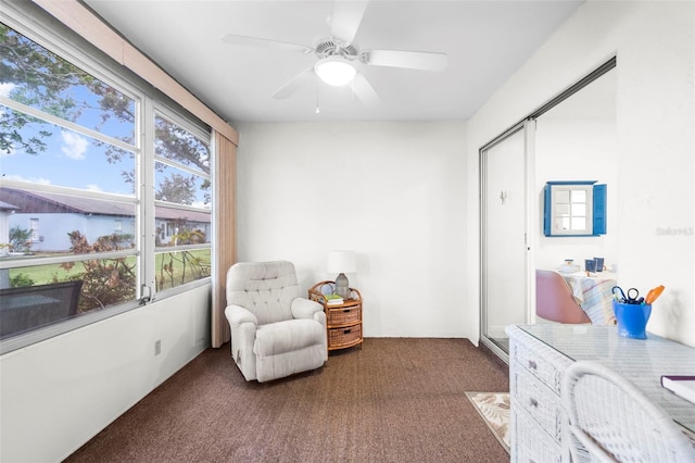 living area featuring ceiling fan and carpet