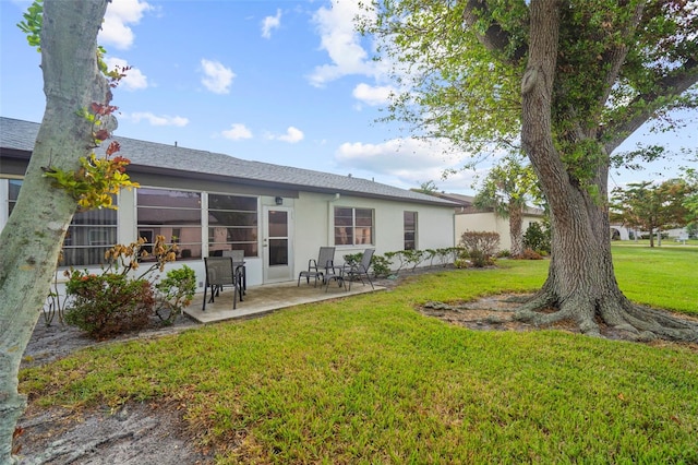 back of property featuring a lawn and a patio area