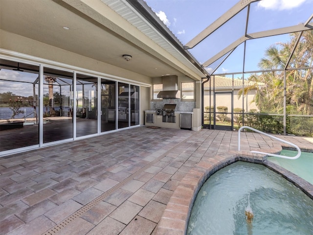 exterior space with a patio area, exterior kitchen, grilling area, and a hot tub