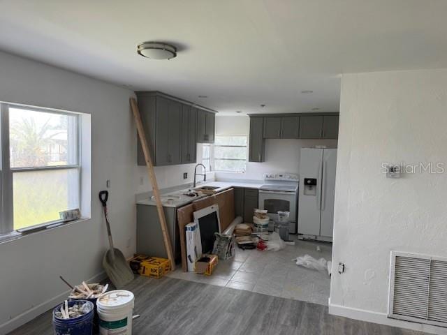 kitchen with white appliances, sink, and hardwood / wood-style flooring