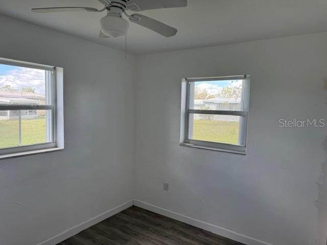 unfurnished room featuring dark hardwood / wood-style flooring, ceiling fan, and a healthy amount of sunlight