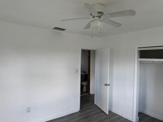 unfurnished bedroom featuring dark wood-type flooring, ceiling fan, and a closet