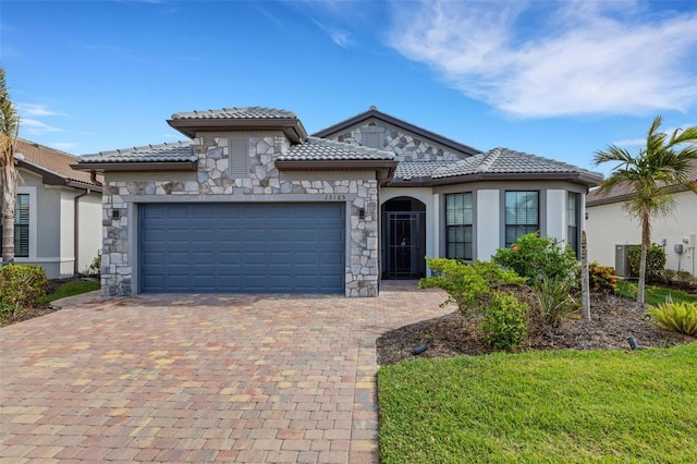 mediterranean / spanish-style house with a garage and central air condition unit