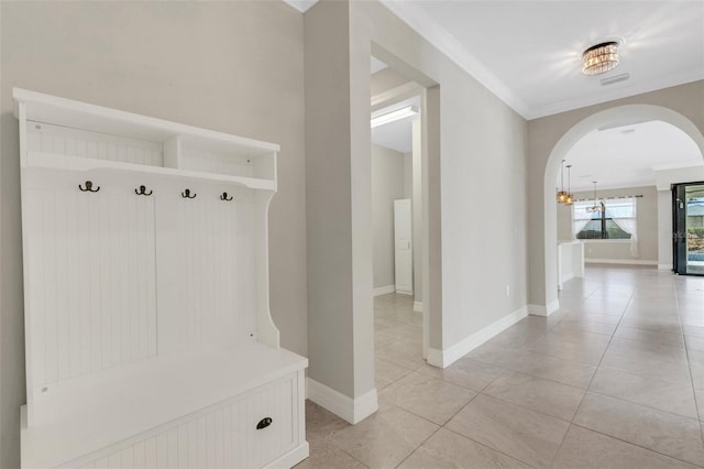 mudroom featuring light tile patterned floors and ornamental molding