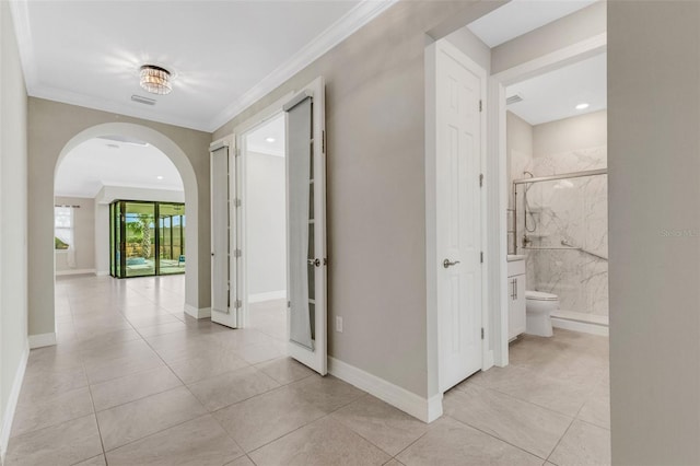 corridor featuring light tile patterned flooring and ornamental molding