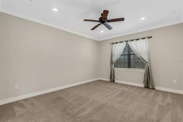 empty room featuring ceiling fan, light colored carpet, and crown molding