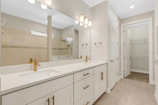 bathroom featuring a tile shower, tile patterned floors, and vanity