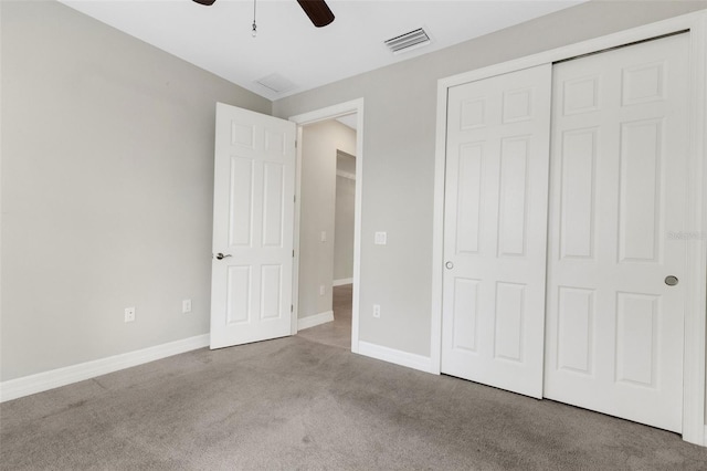 unfurnished bedroom featuring ceiling fan, a closet, and light carpet