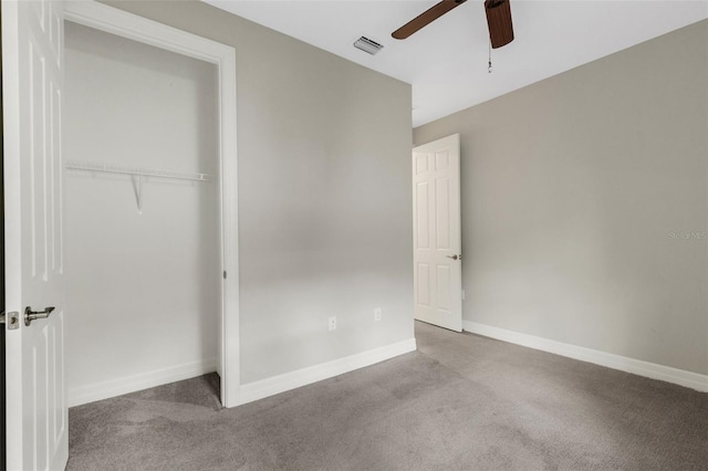 unfurnished bedroom with ceiling fan, light colored carpet, and a closet