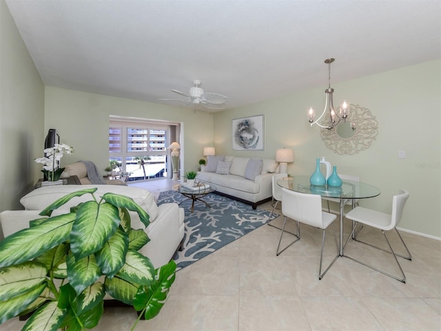 tiled living room with ceiling fan with notable chandelier