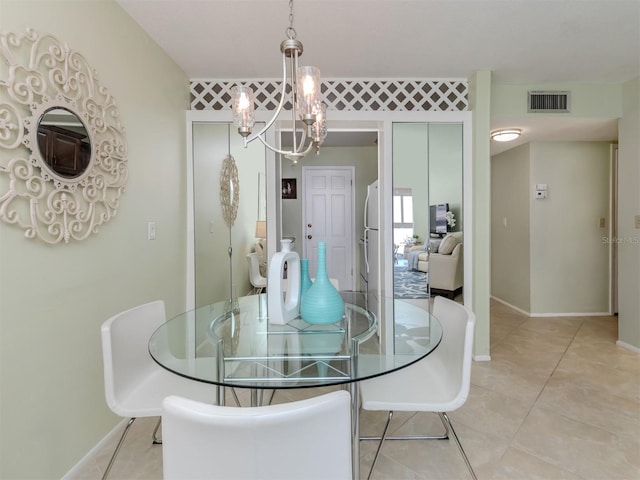 tiled dining area featuring an inviting chandelier