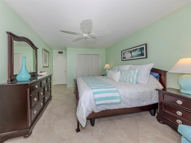 tiled bedroom with ceiling fan and a closet