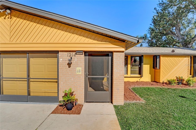 property entrance with a garage and a yard