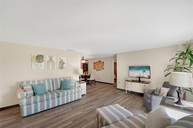 living room featuring ceiling fan, hardwood / wood-style floors, and a textured ceiling