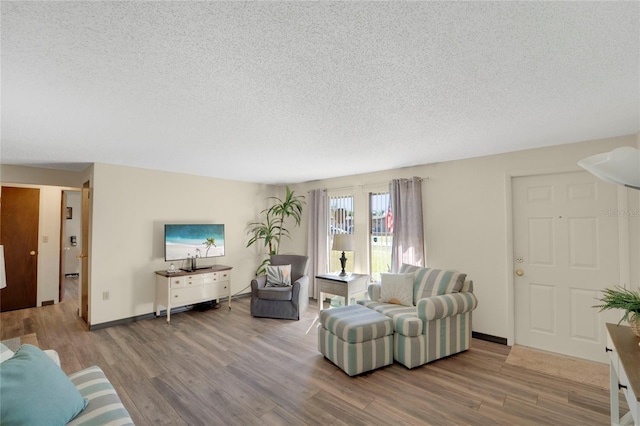 living room featuring light hardwood / wood-style flooring and a textured ceiling