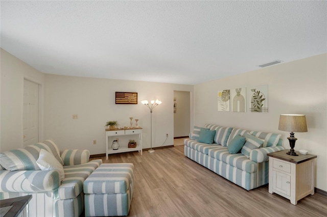 living room featuring a textured ceiling and light hardwood / wood-style floors