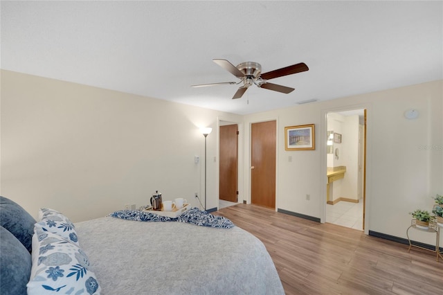 bedroom featuring connected bathroom, ceiling fan, and light wood-type flooring