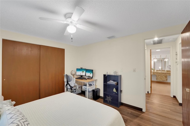 bedroom with ceiling fan, a closet, a textured ceiling, and hardwood / wood-style flooring