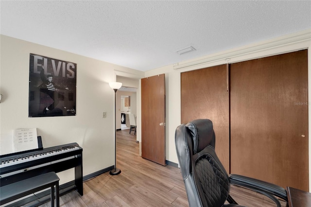 office space with light hardwood / wood-style floors and a textured ceiling