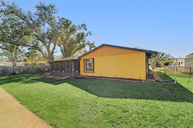 view of home's exterior featuring a lawn and a sunroom