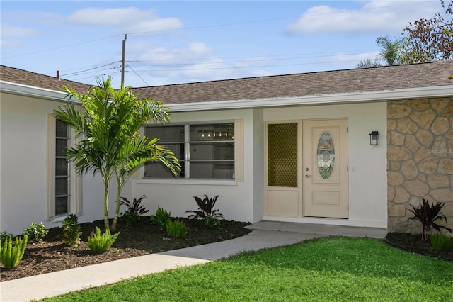 doorway to property featuring a lawn