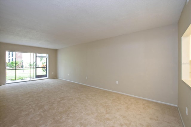 spare room featuring light carpet and a textured ceiling