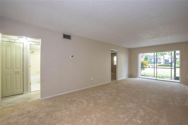 carpeted empty room with a textured ceiling