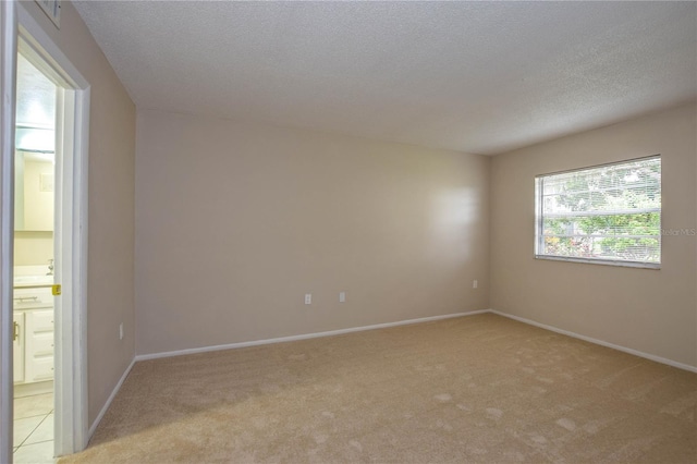 carpeted empty room featuring a textured ceiling