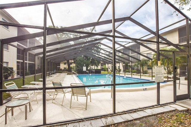 view of swimming pool featuring a patio and a lanai