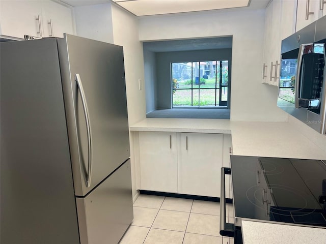 kitchen featuring white cabinets, light tile patterned floors, and stainless steel appliances