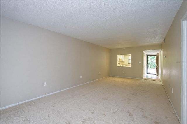 carpeted spare room featuring a textured ceiling