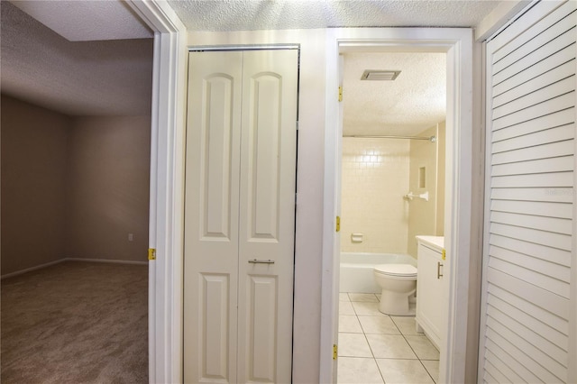 full bathroom featuring tile patterned flooring, a textured ceiling, and toilet