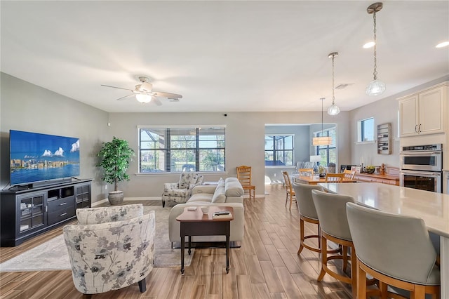 living room with ceiling fan and light hardwood / wood-style flooring