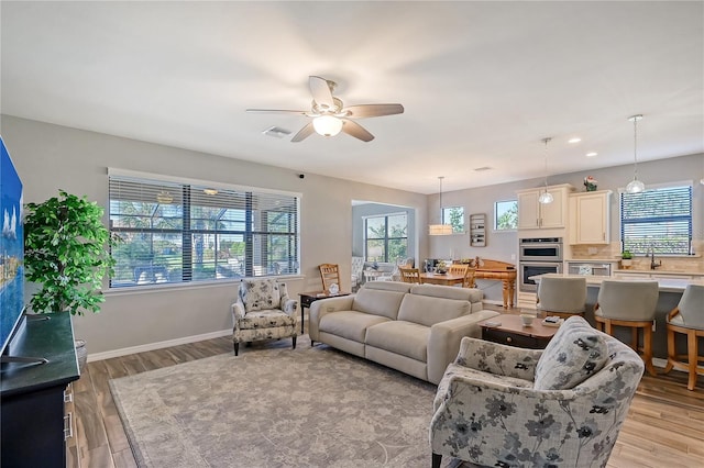 living room with ceiling fan and light wood-type flooring