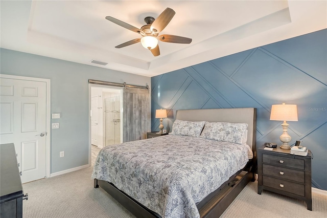 carpeted bedroom with a tray ceiling and ceiling fan